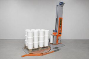 Paletten-Wickelmaschine, daneben eine fertig gewickelte Palette