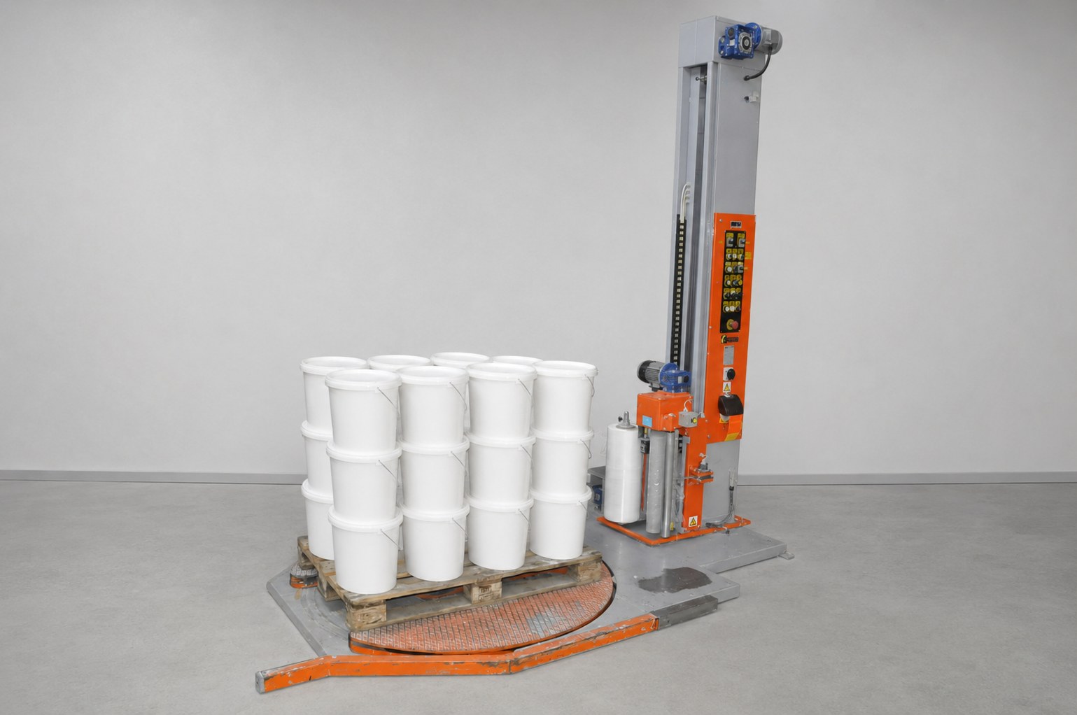 Paletten-Wickelmaschine, daneben eine fertig gewickelte Palette